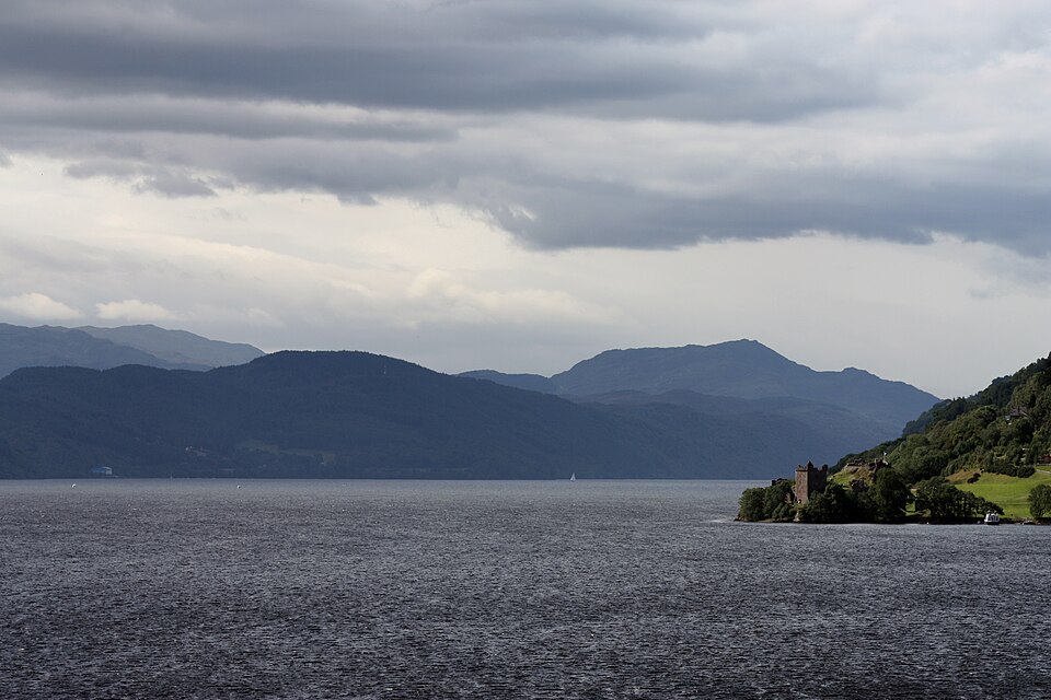 Loch Ness under grey clouds, with Urquhart Castle on the shore